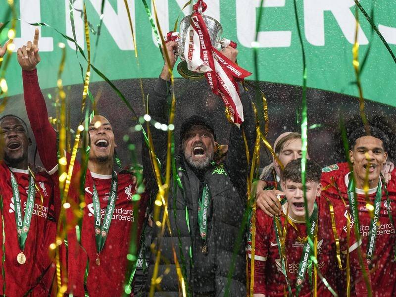 Liverpool manager Jurgen Klopp lifts the League Cup with his team after their Wembley win. (AP PHOTO)